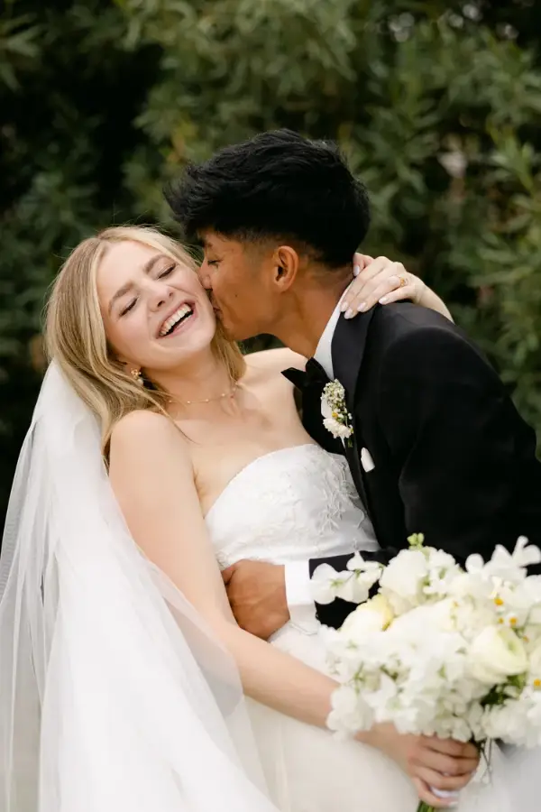 Groom kissing the bride’s cheek